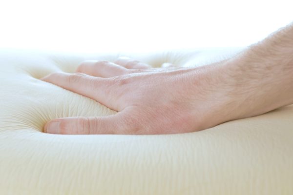 Mano sta toccando il materasso in memory foam